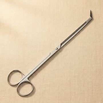 Aquarium plant scissors with long stainless steel blades, 45 degree angled tips and ring handles, lying on linen