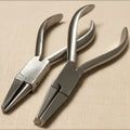Set of two 14 cm orthodontic utility pliers, one with half-round concave jaws and one with round-flat jaws, shown against a white background.