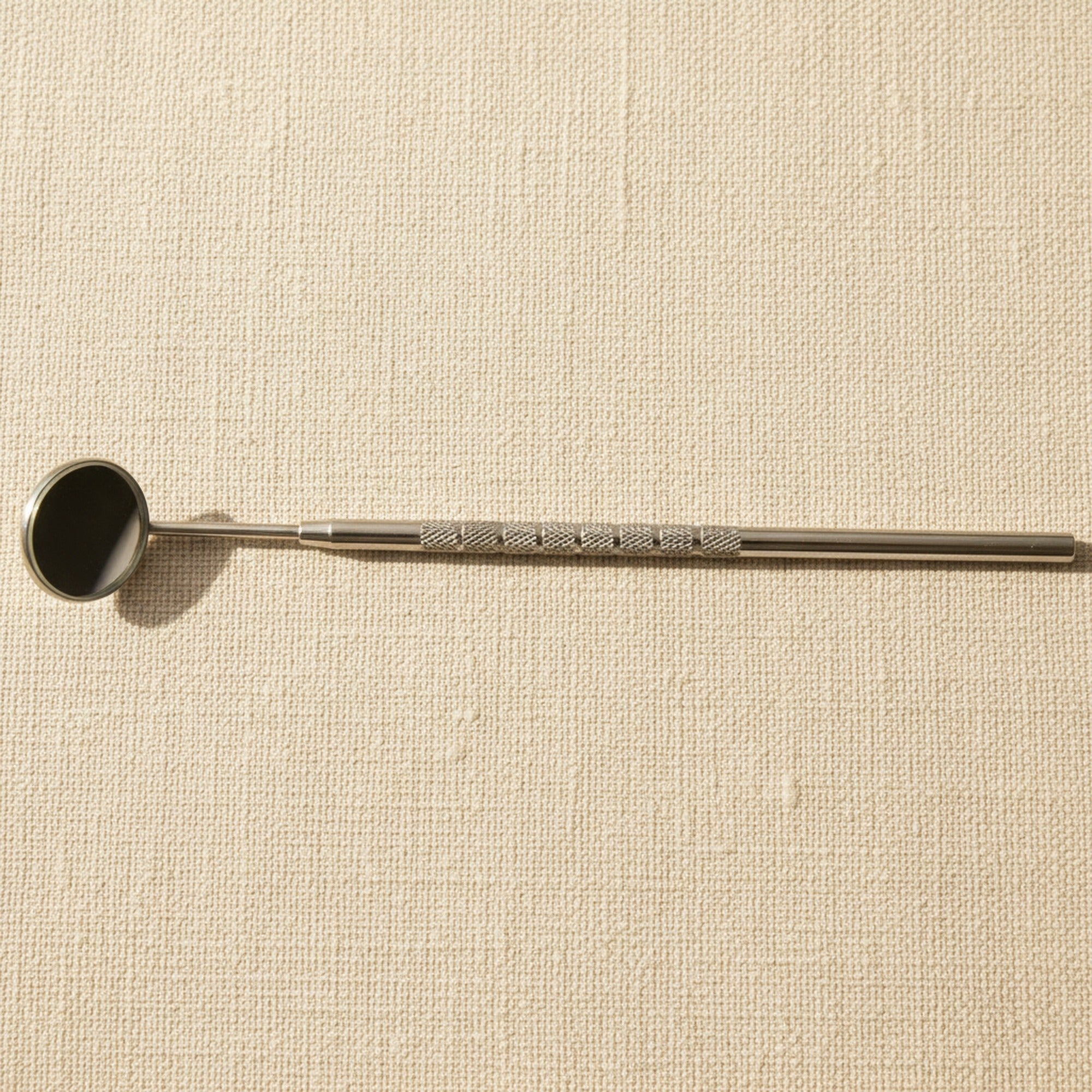 Plain No. 4 dental inspection mirror with integrated stainless steel handle, shown angled on a white background.