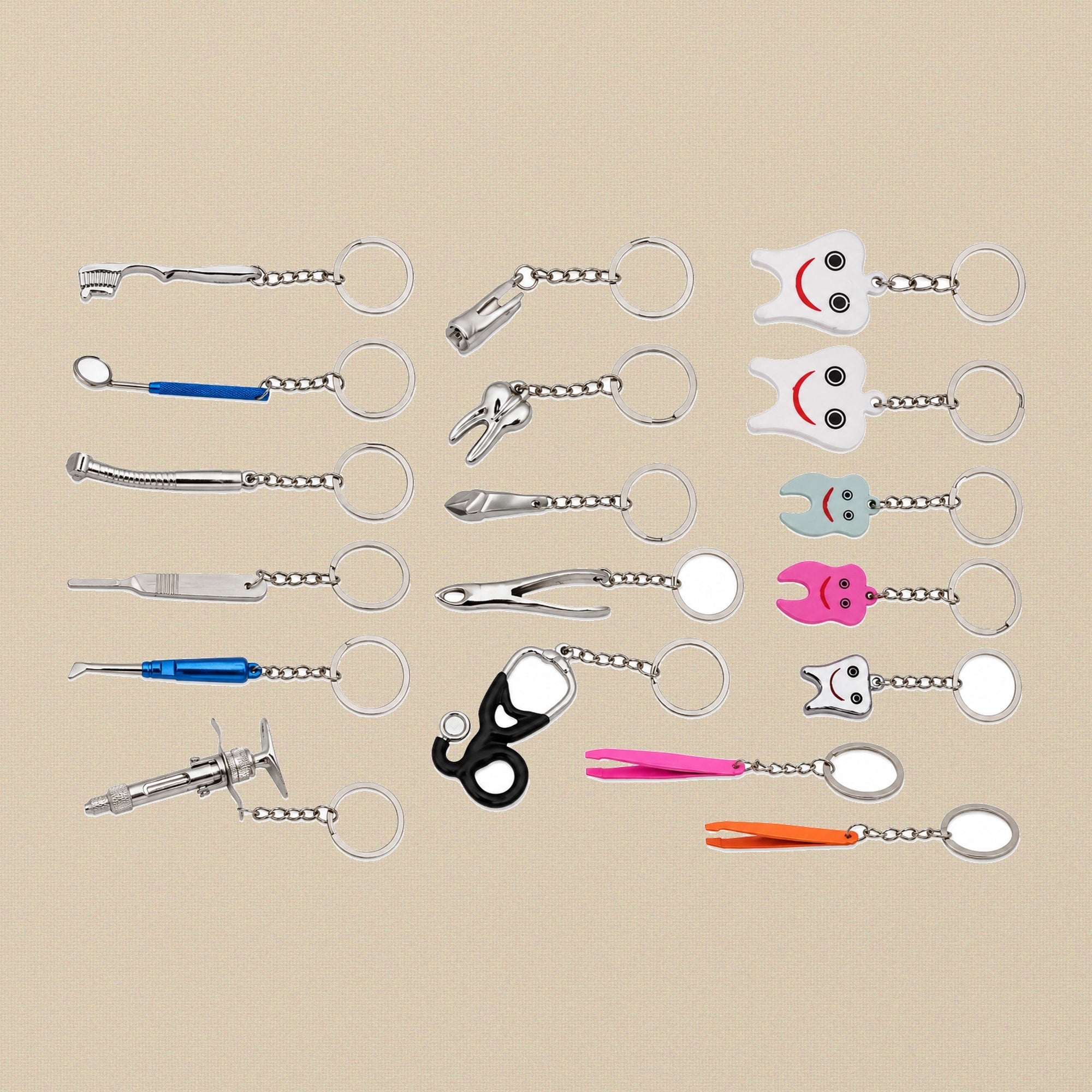 Assortment of miniature dental and medical instrument keyring charms — tooth, syringe, forceps, dental mirror, handpiece and stethoscope designs on a cream background.