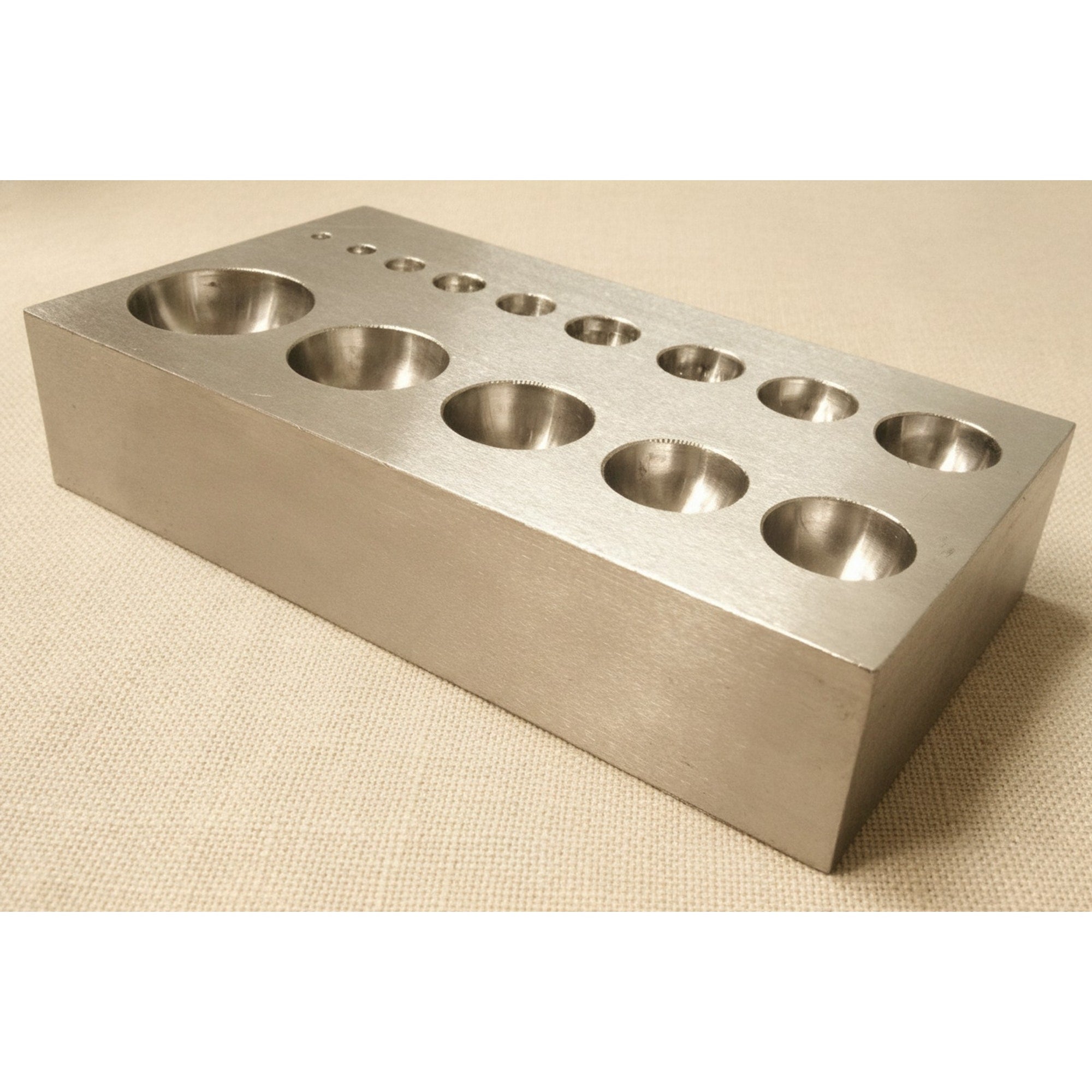 Side view of the 125mm hardened steel dapping block, showing its 25mm thickness.