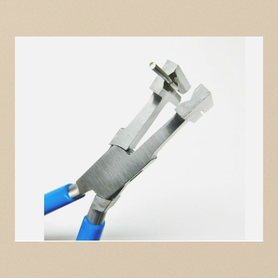 Close-up of coil cutting pliers with the jaws open, showing the pin and the slotted jaw tip