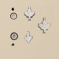 Hardened steel disc cutter block with three maple leaf shaped punches arranged neatly beside it.