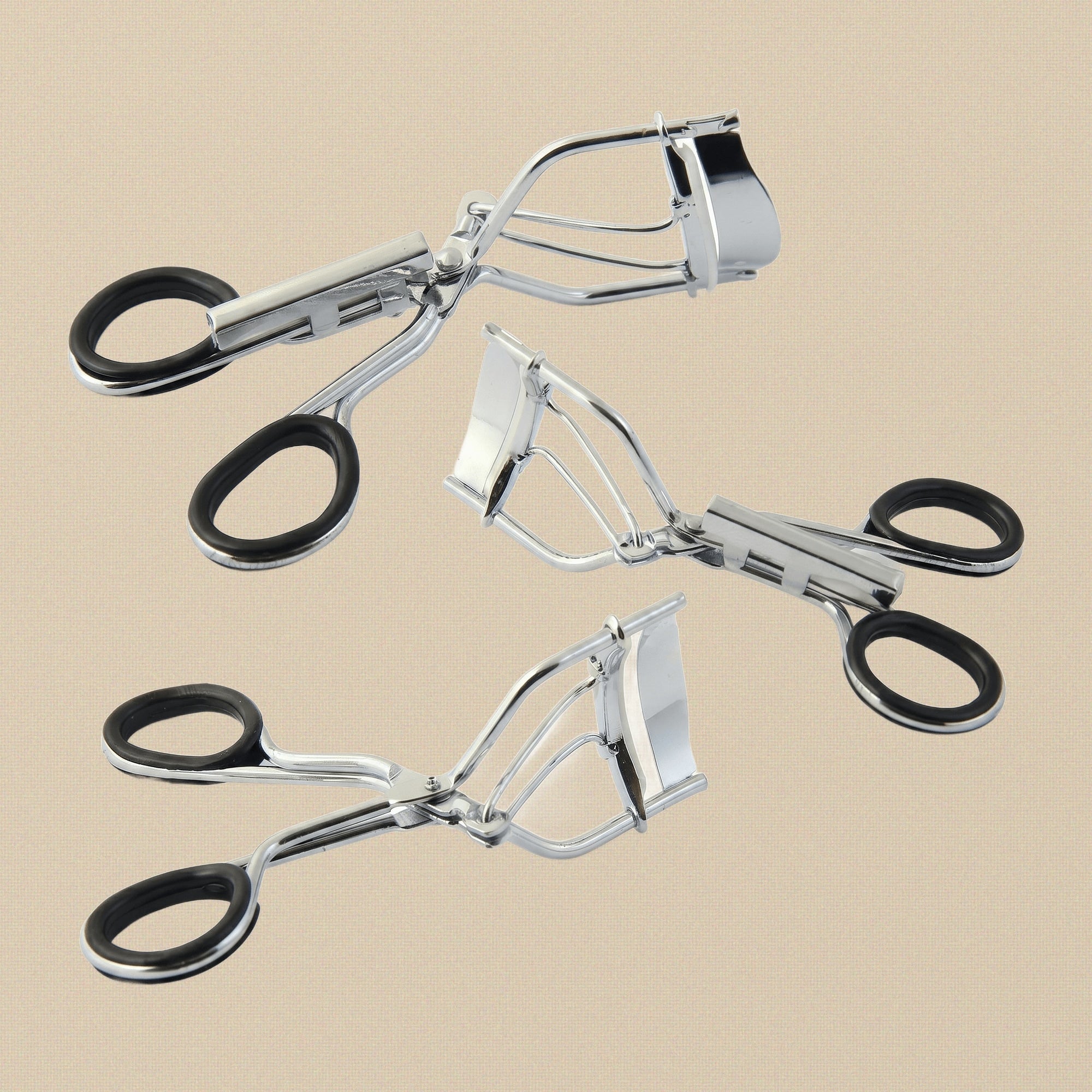 Front view of the stainless steel eyelash curler showing the curved clamp and black rubber handle grips.