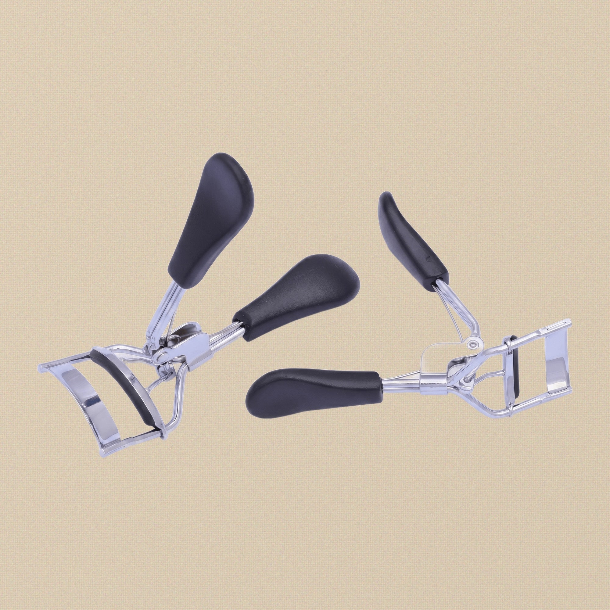 Front view of the stainless steel eyelash curler with black soft-grip handles.