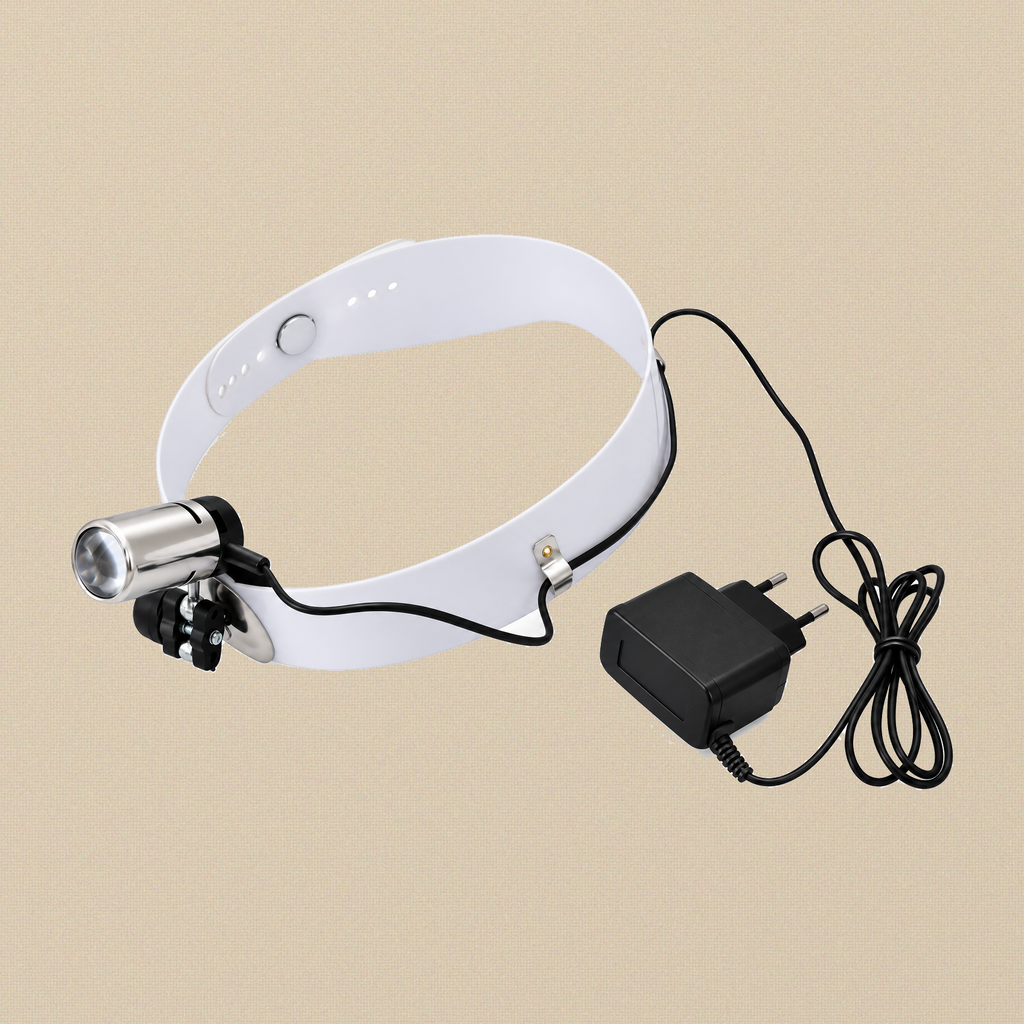 Head-mounted examination lamp on an adjustable white headband, with its plug-in charger