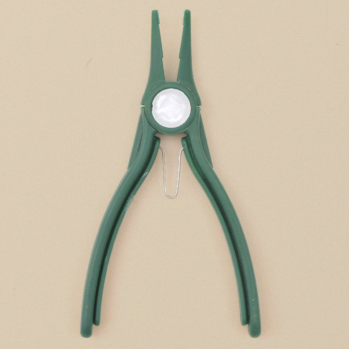Green plastic chain nose pliers standing, jaws upward