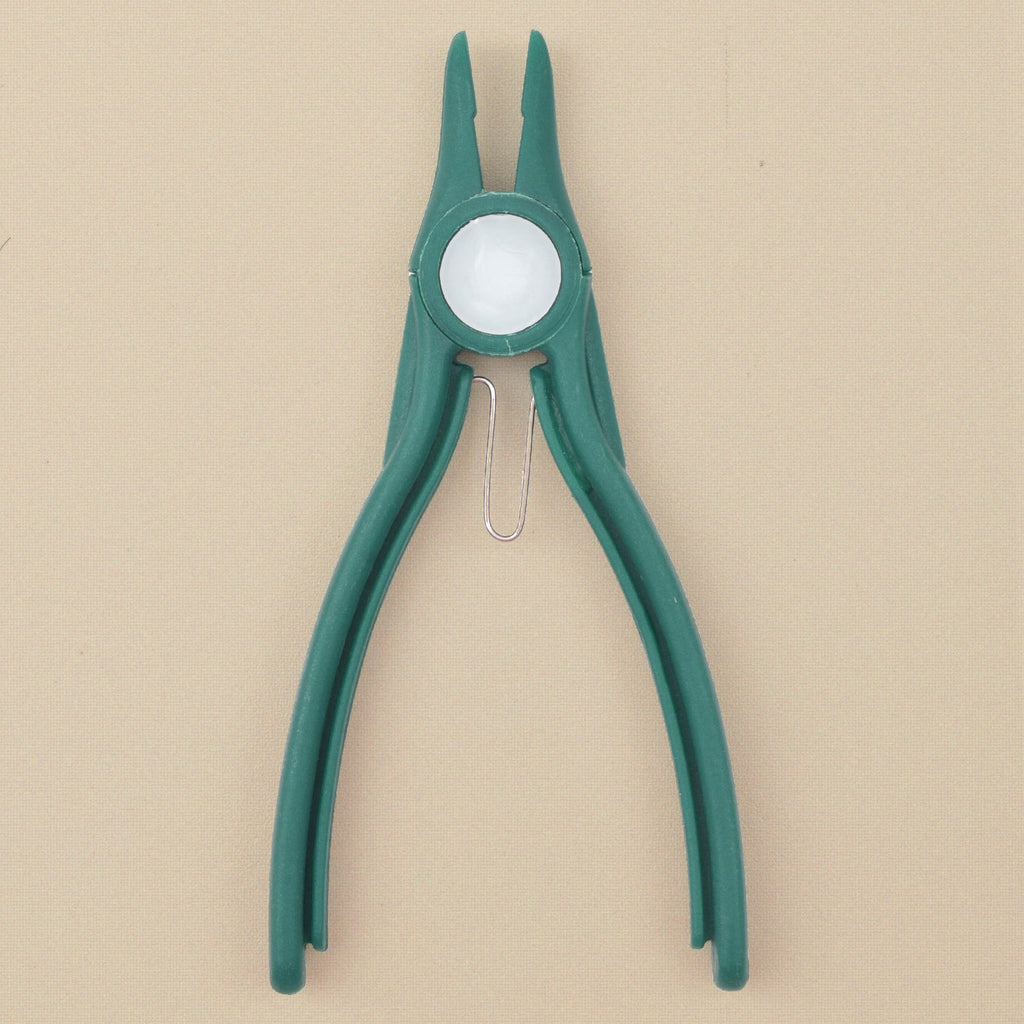 Green plastic flat nose pliers standing, jaws upward