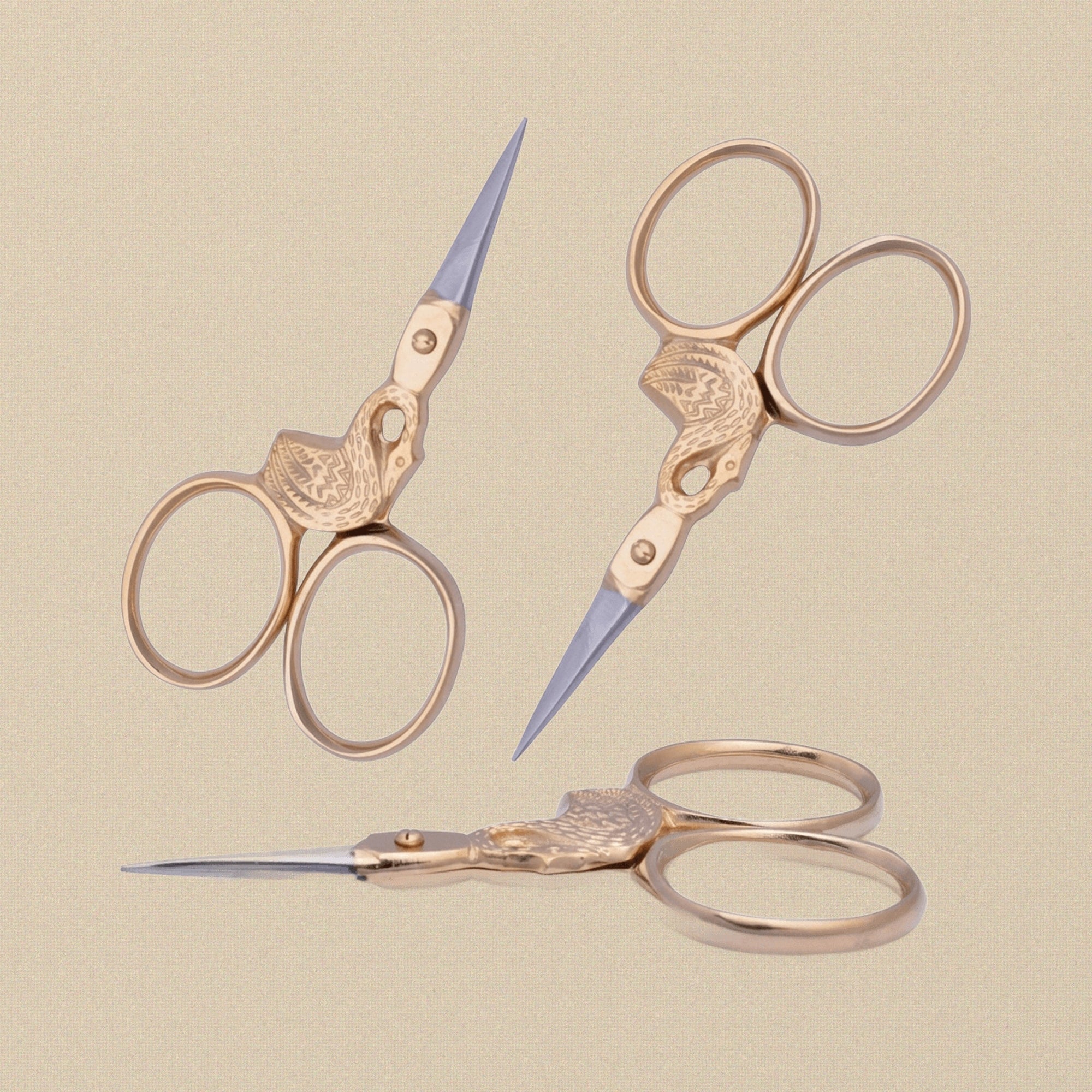 Gold-plated swan-shaped embroidery scissors on a white background.