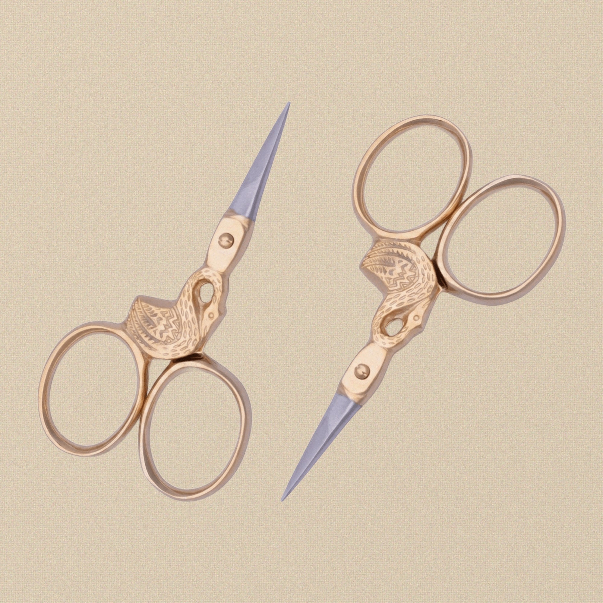 The swan scissors held in hand to show scale and the elegant handle design.