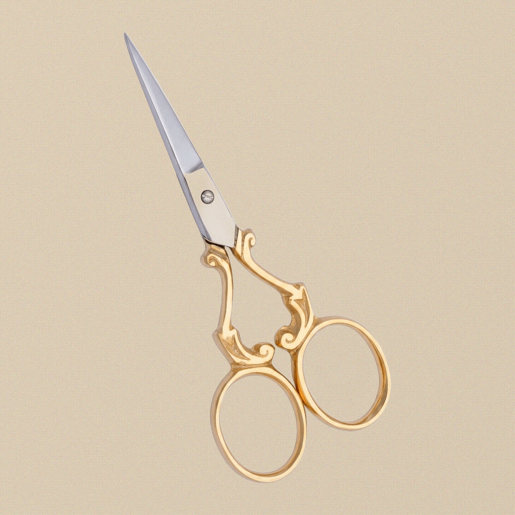 Detail shot of the fine, sharp points and gold-plated finish of the ornate embroidery scissors.