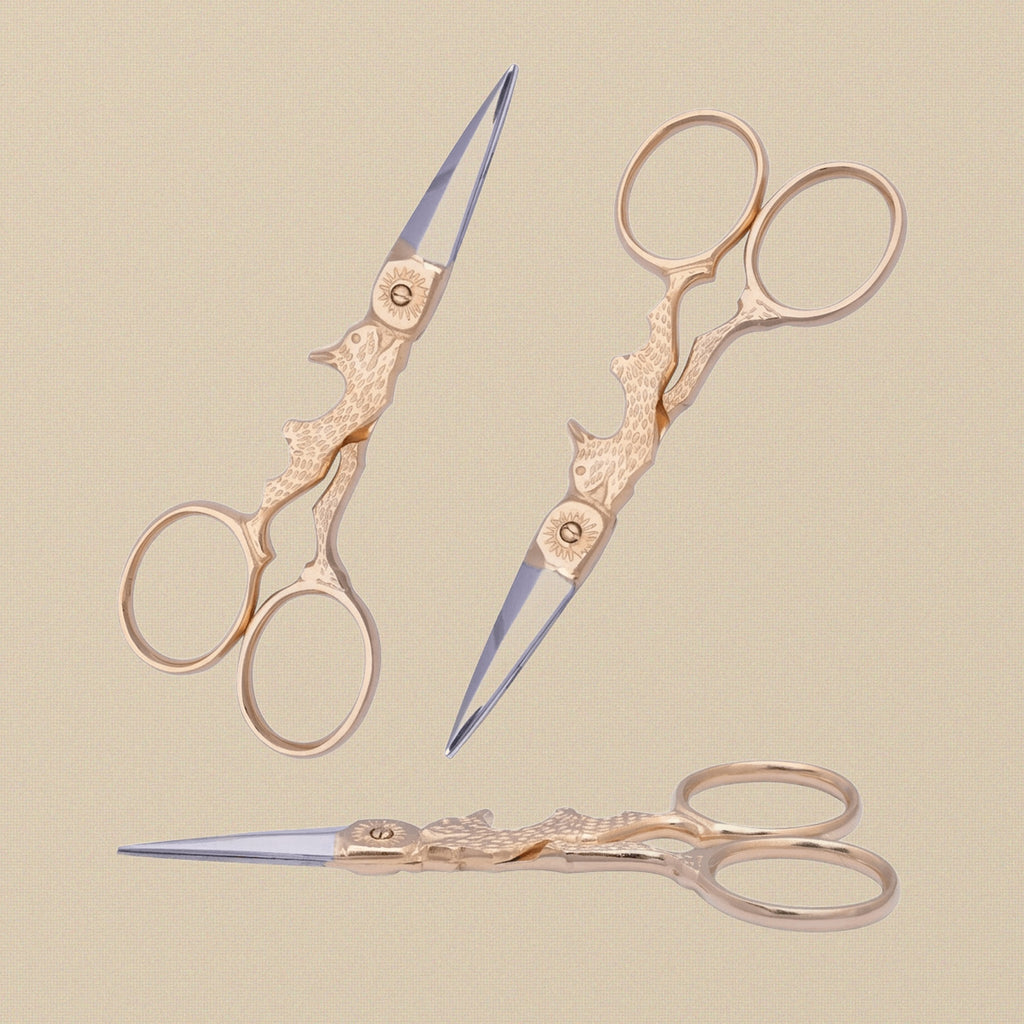 Gold-plated rabbit-shaped embroidery scissors on a white background.