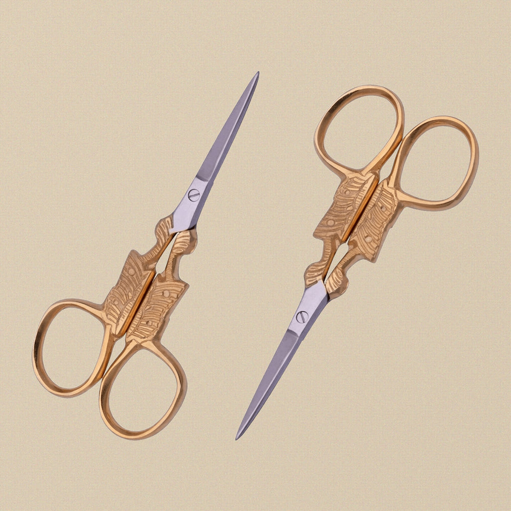 Gold-plated butterfly embroidery scissors with fine points, shown closed on a white background.