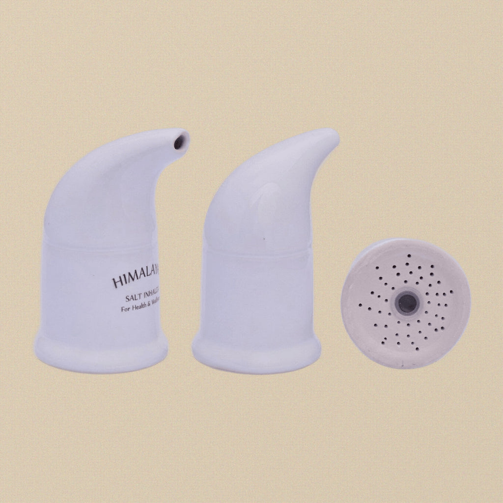 A hand holding the ceramic salt pipe inhaler to show its scale.