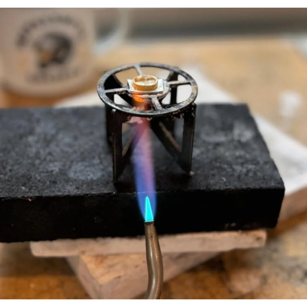 The titanium stand on a soldering block with a small piece being heated