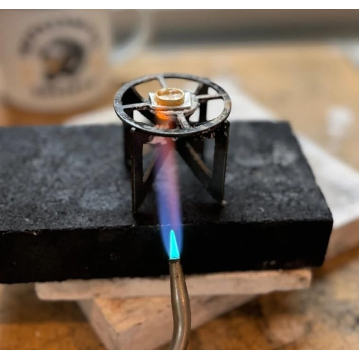 The titanium stand on a soldering block with a small piece being heated