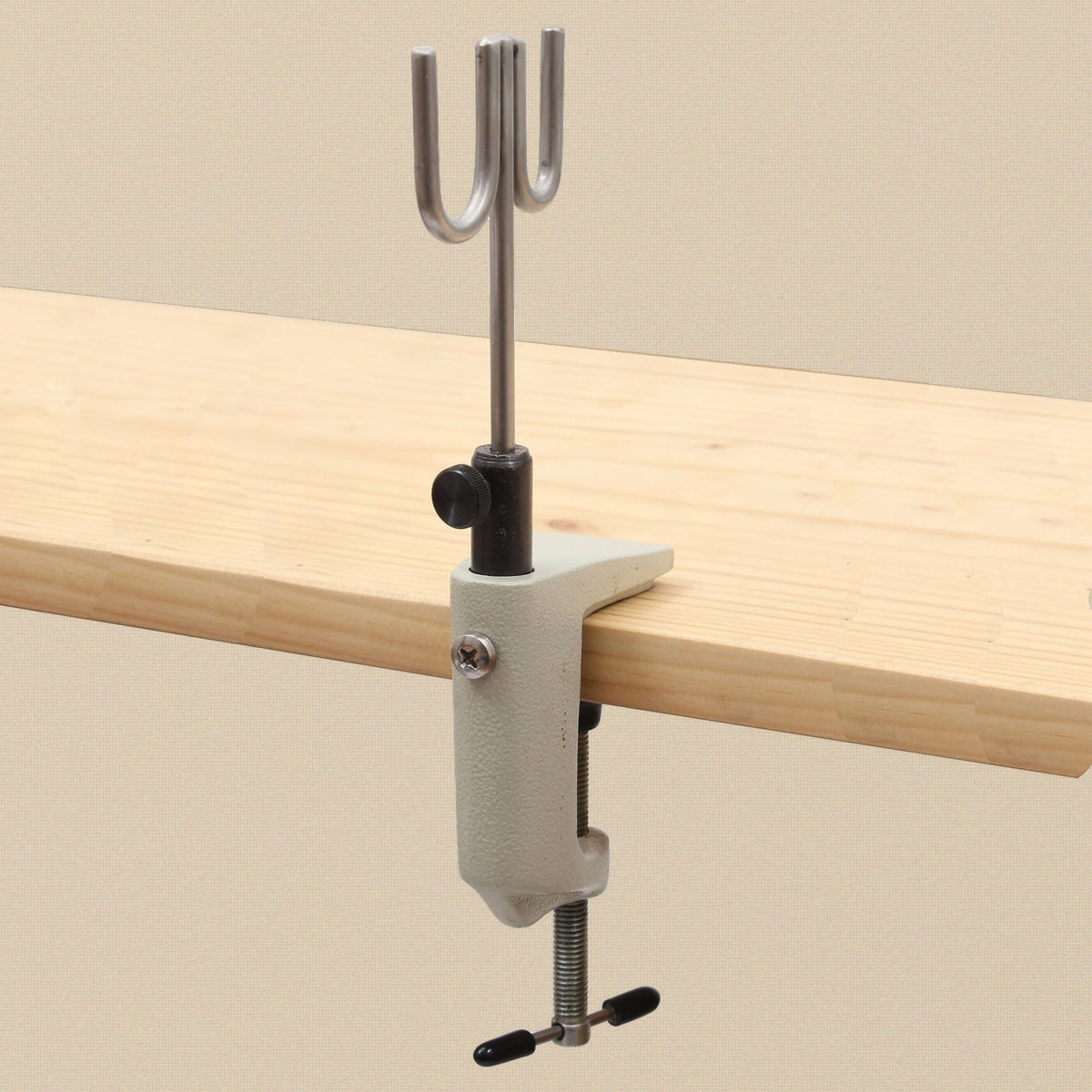 Bench clamp torch holder clamped to the edge of a pine board with the wire rest pointing up